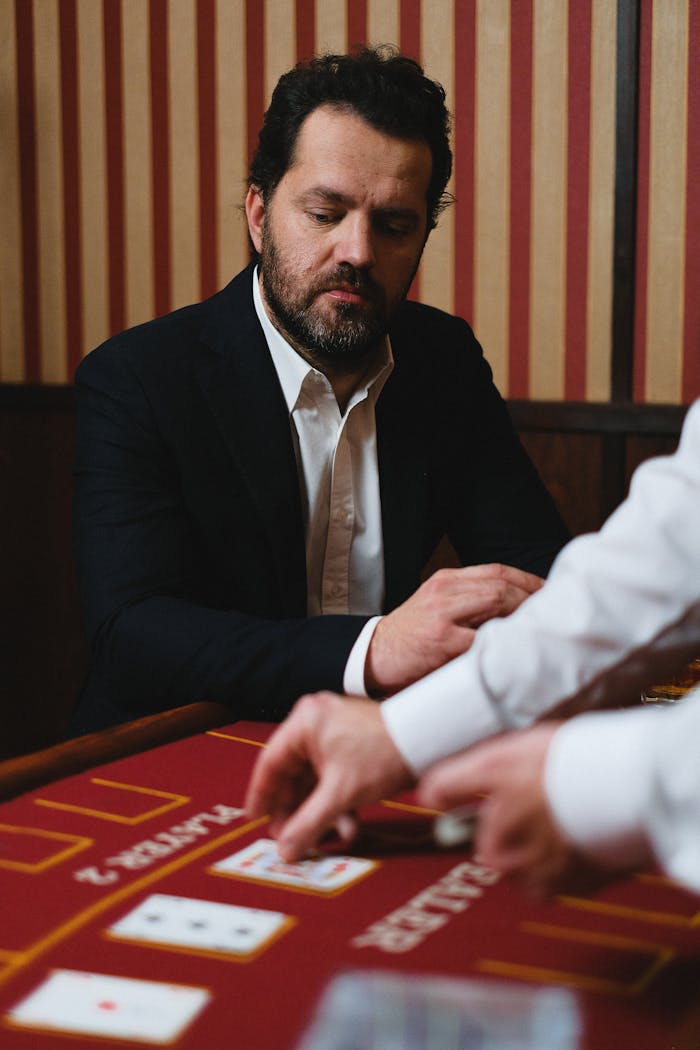 Man in a casino engaged at a card game, focusing on his strategy.